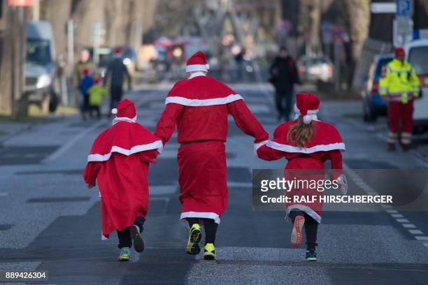 Participants dressed in Father Christmas costumes take part in the traditional Santa Claus run in Michendorf, eastern Germany, on December 10, 2017....