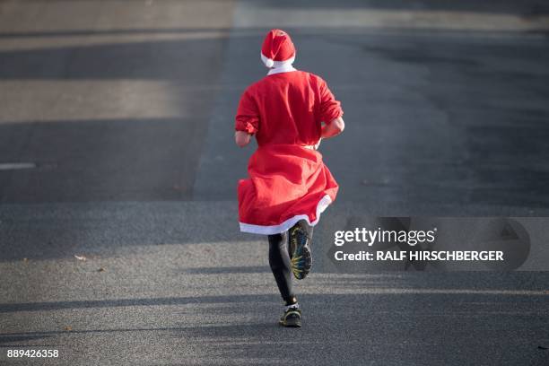 Participant dressed in a Father Christmas costume takes part in the traditional Santa Claus run in Michendorf, eastern Germany, on December 10, 2017....