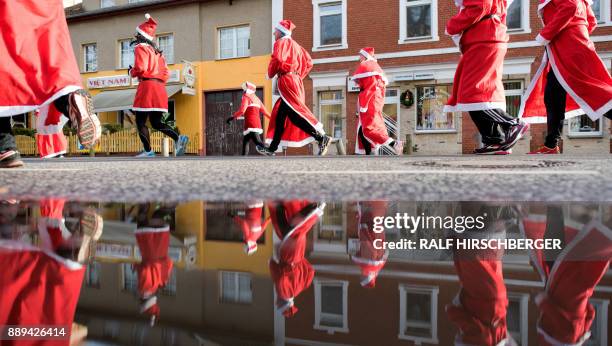 Participants dressed in Father Christmas costumes take part in the traditional Santa Claus run in Michendorf, eastern Germany, on December 10, 2017....