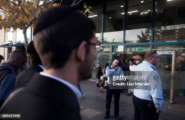 Israeli Police officers and security guard are seen at the scene of an attack at the Jerusalem Central Bus Station on December 10, 2017 in Jerusalem,...