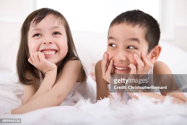 young sibling playing with feathers - children only stock pictures, royalty-free photos & images