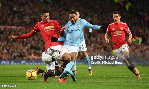 Chris Smalling of Manchester United tackles Raheem Sterling of Manchester City as Ander Herrera of Manchester United looks on during the Premier...