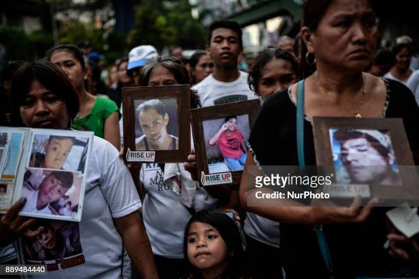 Relatives of victims of extrajudicial killings carry pictures of their loved ones during a protest in Quezon city, Metro Manila, Philippines,...