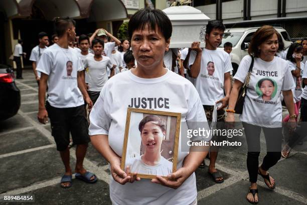Rosanna Brondial holds a picture of her 13-year-old son Jayross Brondial, who was killed by an unidentified gunman, during his funeral in Pasay,...