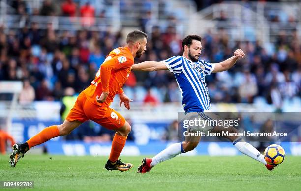 Alberto de la Bella of Real Sociedad duels for the ball with Borja Gonzalez of Malaga CF during the La Liga match between Real Sociedad de Futbol and...