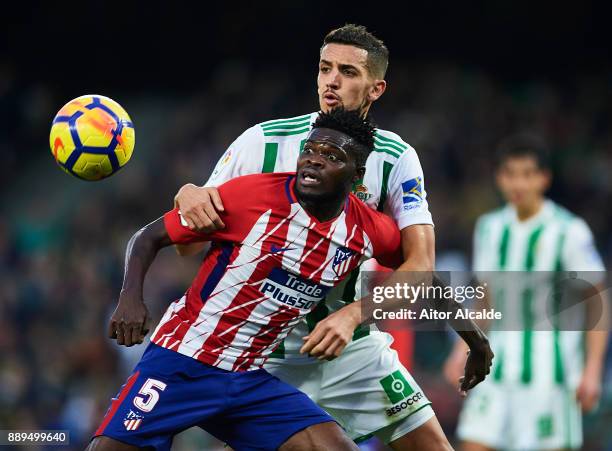 Thomas Partey of Club Atletico de Madrid competes for the ball with Zouhair Feddal of Real Betis Balompie during the La Liga match between Real Betis...