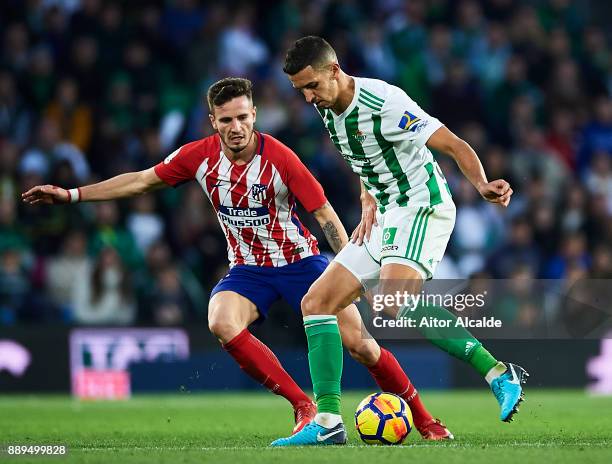 Zouhair Feddal of Real Betis Balompie being followed by Saul Niguez of Club Atletico de Madrid during the La Liga match between Real Betis and...