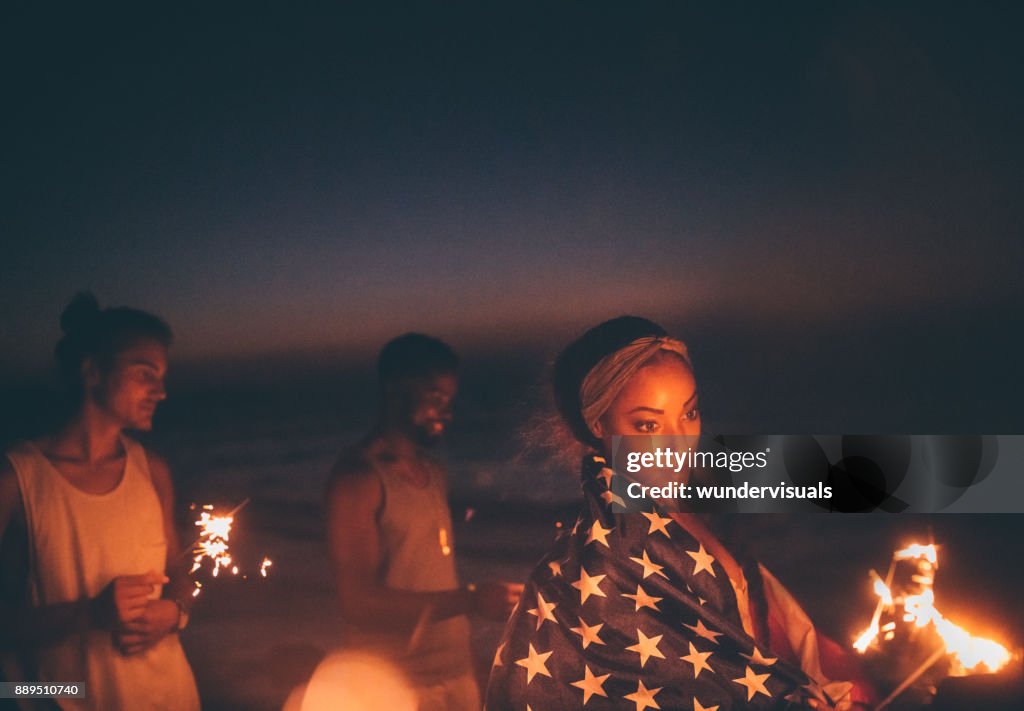 Young multi-ethnic hipster friends celebrating fourth of July with sparklers