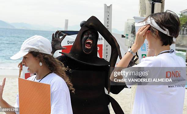 Demonstrator fancy dressed as the Chagas disease's vector, the 'assassin bug' , frightens other activists during a rally July 9, 2009 at Copacabana...