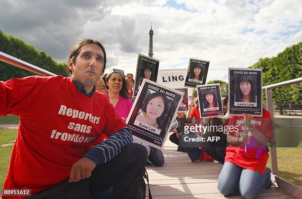 People take part in a demonstration, organized by French association Reporters Without Borders, in front of the Eiffel Tower in Paris, on July 9 to...