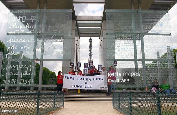 People take part in a demonstration, organized by the French association Reporters Without Borders, in front of the Eiffel Tower in Paris, on July 9...