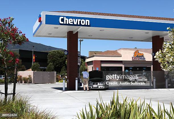 Chevron customer looks under the hood of his car at a Chevron service station July 9, 2009 in Greenbrae, California. Chevron will report quarterly...