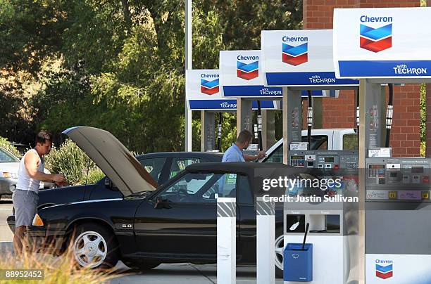 Chevron customer looks under the hood of his car at a Chevron service station July 9, 2009 in Greenbrae, California. Chevron will report quarterly...