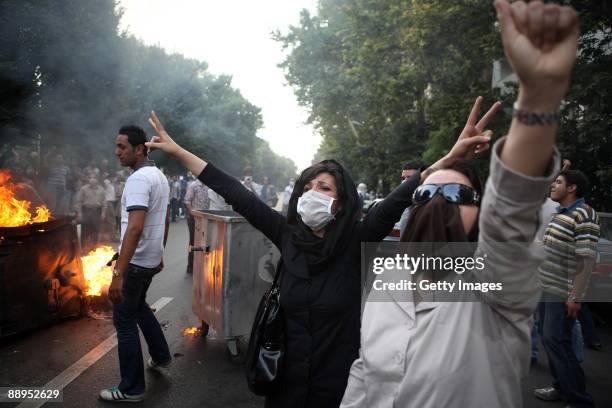 Iranian women raise their arms in protest as demonstrators burn rubbish in the streets on July 9, 2009 in Tehran, Iran. Following recent unrest in...