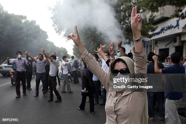 Woman wearing a mask raises her arms in protest as demonstrators gather in the streets on July 9, 2009 in Tehran, Iran. Following recent unrest in...