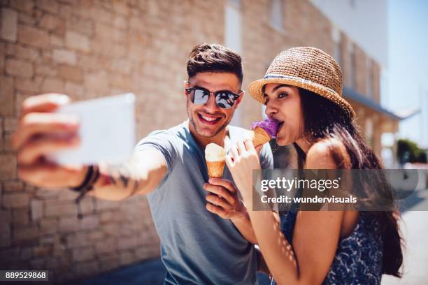 pareja joven comer helados y tomar autorretratos vacaciones de verano - city 2 fotografías e imágenes de stock