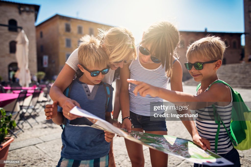 Family checking map in italian town of Massa Marittima in Tuscany