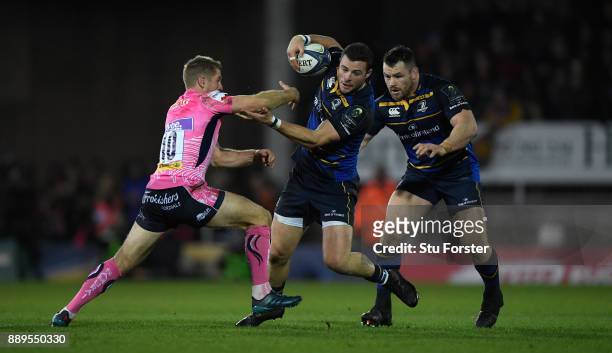 Leinster centre Robbie Henshaw is tackled by Gareth Steenson as Cian Healy looks on during the European Rugby Champions Cup match between Exeter...