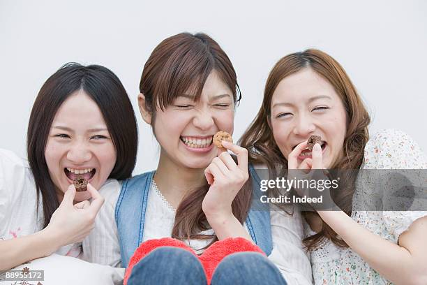 three young women holding cookie, smiling - only japanese stock pictures, royalty-free photos & images