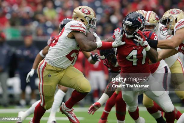 Carlos Hyde of the San Francisco 49ers runs the ball stiff-arming Zach Cunningham of the Houston Texans in the first quarter at NRG Stadium on...