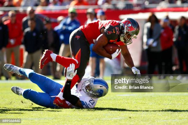 Running back Doug Martin of the Tampa Bay Buccaneers is stopped by cornerback Darius Slay of the Detroit Lions after hauling in a 12-yard pass from...
