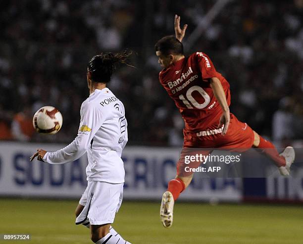 Ecuador's Liga de Quito player Norberto Araujo vies for the ball with Brazil's Internacional Andres D'Alessandro during the second leg football match...