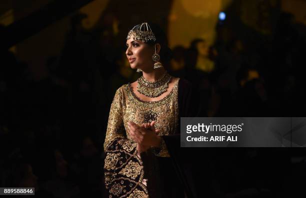 Model presents a creation by designer Umsha by Uzma Babar on the last day of the Pantene Hum Bridal Couture Week in Lahore on December 10, 2017. /...