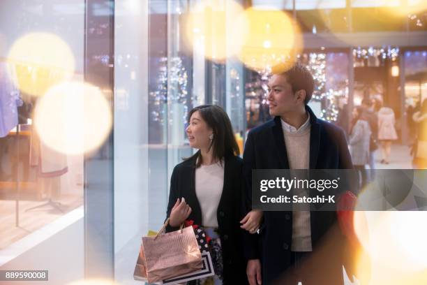 jeune femme et du mari shopping ensemble dans la nuit de noël - gift japan photos et images de collection