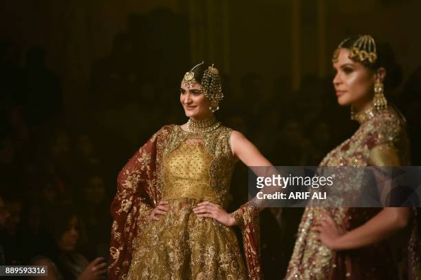 Models present creations by designer Umsha by Uzma Babar on the last day of the Pantene Hum Bridal Couture Week in Lahore on December 10, 2017. / AFP...