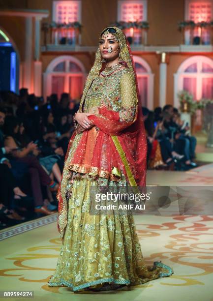 Model presents a creation by designer Umsha by Uzma Babar on the last day of the Pantene Hum Bridal Couture Week in Lahore on December 10, 2017. /...