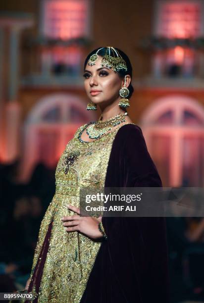 Model presents a creation by designer Umsha by Uzma Babar on the last day of the Pantene Hum Bridal Couture Week in Lahore on December 10, 2017. /...