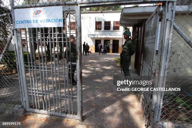 Two members of the Venezuelan military guard the gate to a voting station during the country's municipal elections, in San Cristobal, Tachira state...