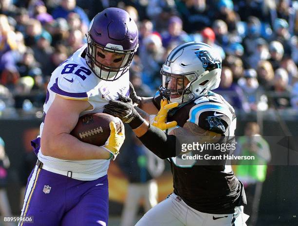 Kyle Rudolph of the Minnesota Vikings fends off Daryl Worley of the Carolina Panthers during their game at Bank of America Stadium on December 10,...