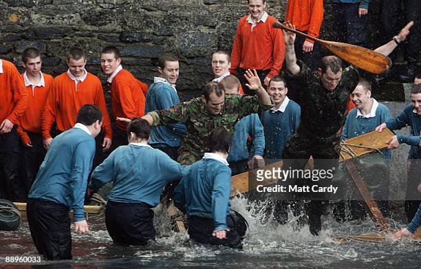 Royal Navy personel jump in the water in the harbour at the Piers Cellars training centre as they take part in team-building exercise close to the...