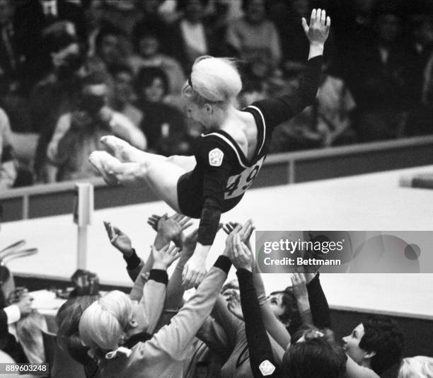 Vera Caslavska of Czechoslovakia is tossed into the air by her fellow gymnasts after judges awarded her 9.90 of a possible ten pints in the uneven...