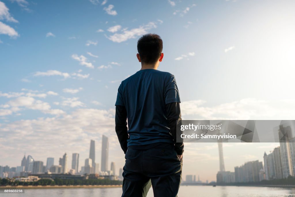 A man standing against the riverside.