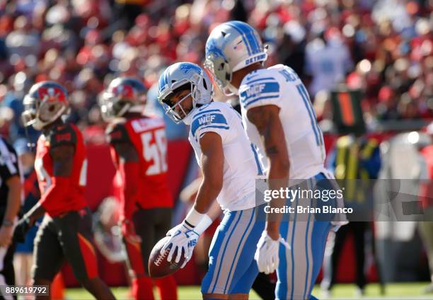 Wide receiver Golden Tate of the Detroit Lions pretends to putt a golfball in front of wide receiver Marvin Jones as he celebrates in the end zone...