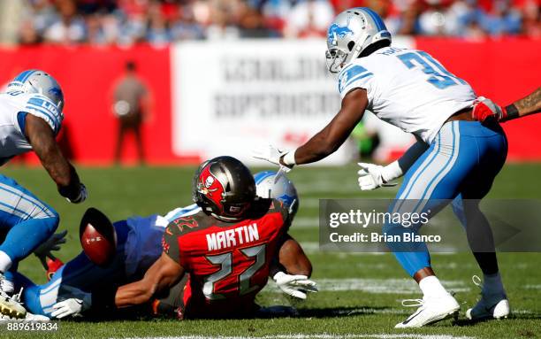 Running back Doug Martin of the Tampa Bay Buccaneers fumbles the ball allowing it to be recovered by defensive back D.J. Hayden of the Detroit Lions...