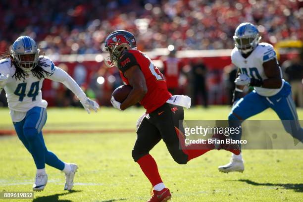 Running back Doug Martin of the Tampa Bay Buccaneers looks to get around linebacker Jalen Reeves-Maybin of the Detroit Lions during a carry in the...
