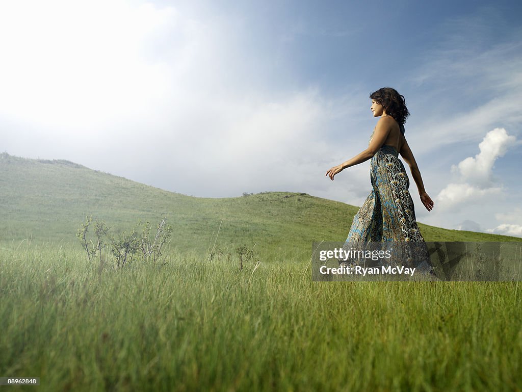 Woman walking in grassy field, low angle