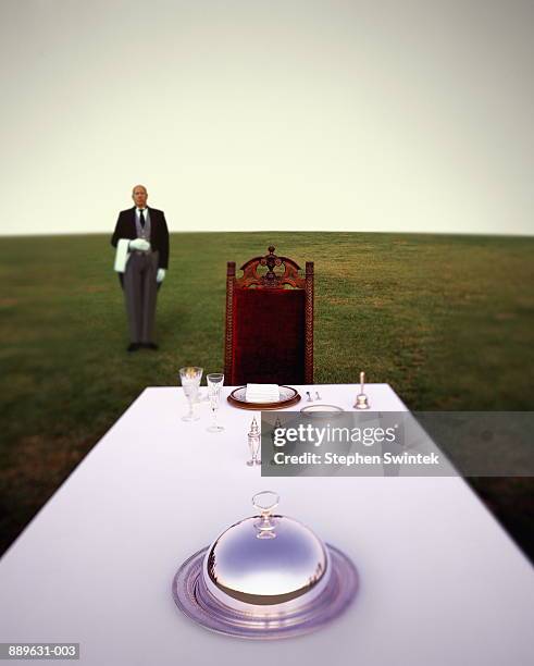 butler standing behind table with setting (digital composite) - etiquette stock-fotos und bilder