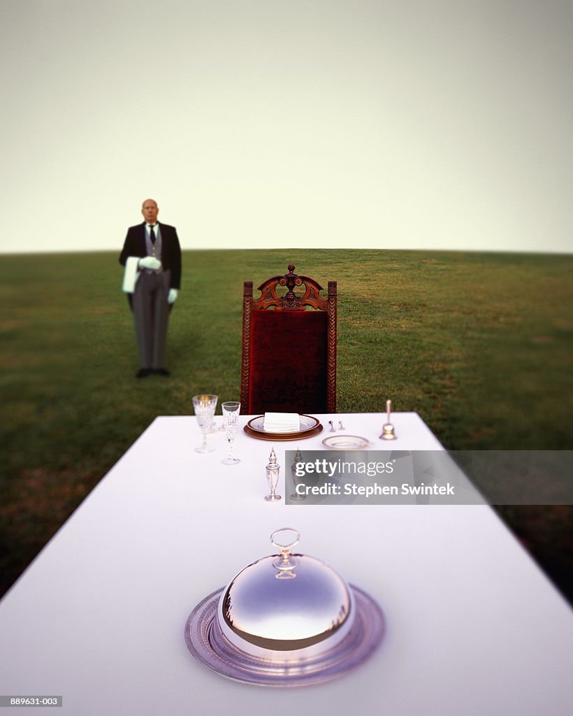 Butler standing behind table with setting (Digital Composite)