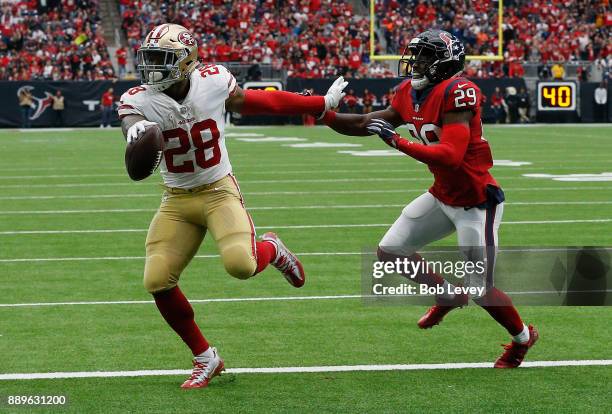 Carlos Hyde of the San Francisco 49ers scores in the second quarter as he beats Andre Hal of the Houston Texans to the endzone at NRG Stadium on...