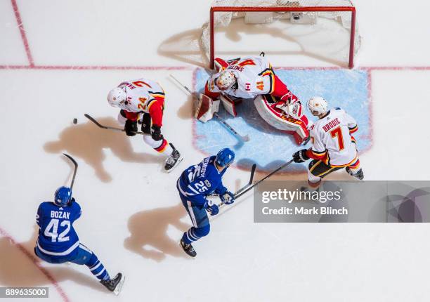 Tyler Bozak and James van Riemsdyk go to the net against Mike Smith, TJ Brodie, and Travis Hamonic of the Calgary Flames during the first period at...