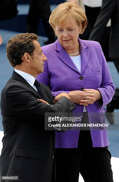 German Chancellor Angela Merkel speaks with French President Nicolas Sarkozy after a meeting of the Group of Eight and participating African...