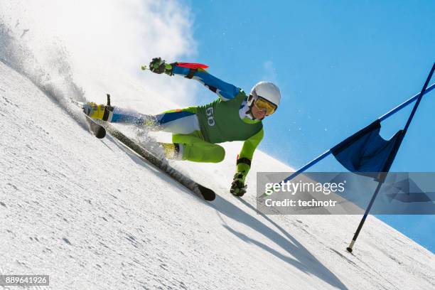 professionele alpine skiër compeeting bij giant slalom race tegen de blauwe hemel - slalom stockfoto's en -beelden