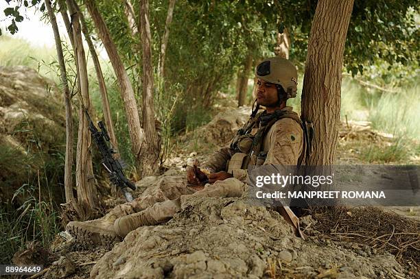Marine of 1st Combat Engineering Battalion of 2nd Marine Expeditionary Brigade rests in Garmsir district of Afghanistan's Helmand Province on July...