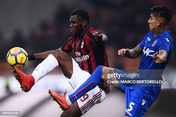 Milan's midfielder Franck Kessie from Ivory Coast fights for the ball with Bologna's defender Erick Pulgar during the Italian Serie A football match...