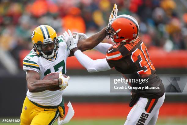 Davante Adams of the Green Bay Packers stiff arms Jason McCourty of the Cleveland Browns in the second half at FirstEnergy Stadium on December 10,...