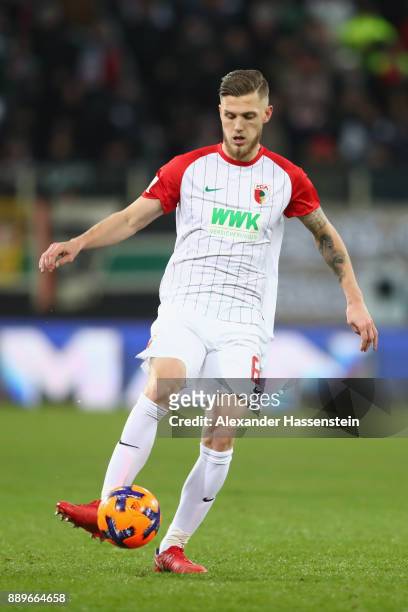 Jeffrey Gouweleeuw of Augsburg runs with the ball during the Bundesliga match between FC Augsburg and Hertha BSC at WWK-Arena on December 10, 2017 in...